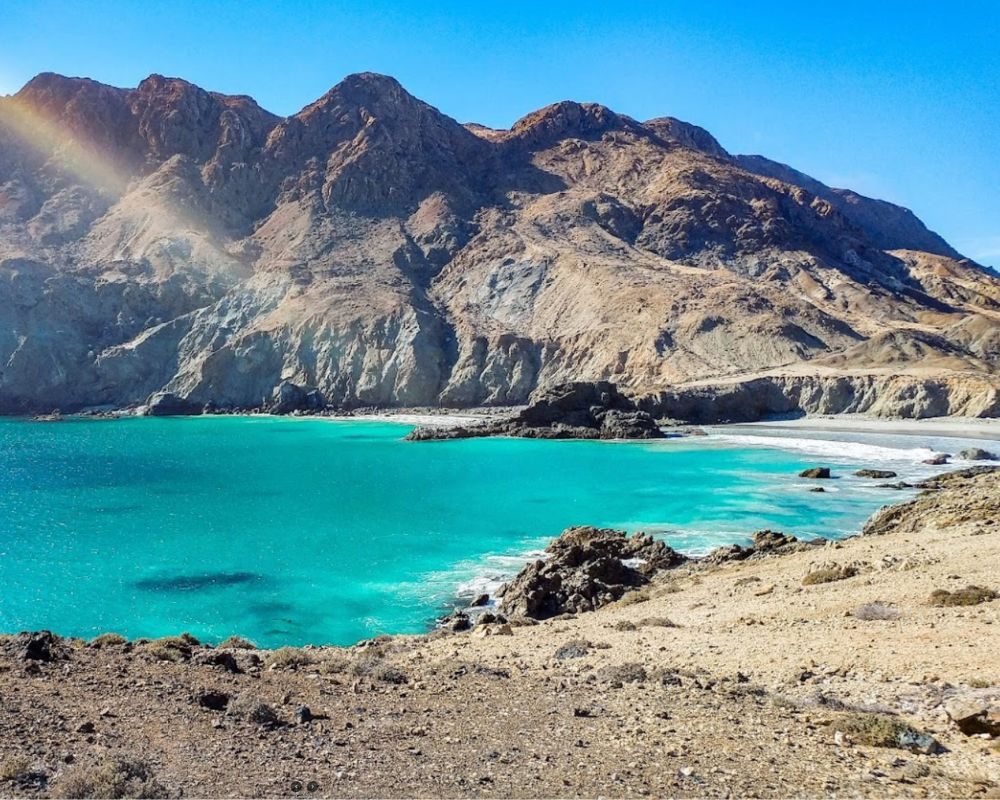 Bare brown mountains of Isla Cedros above a turquoise cove